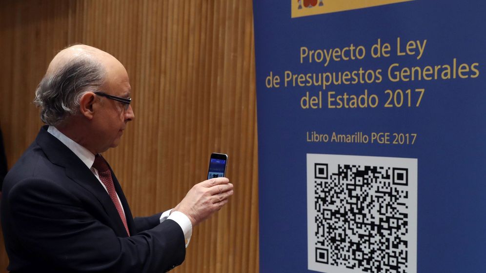 Foto: El ministro de Hacienda, Cristóbal Montoro, escanea con el móvl el código QR del proyecto de Ley de Presupuestos Generales del Estado. (EFE)